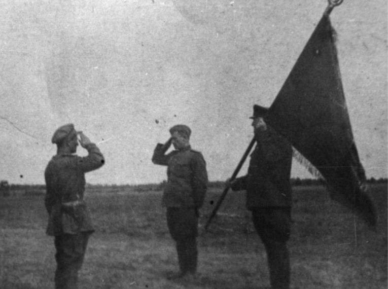 Командир 219 стрелковой дивизии генерал-майор  В. П. Котельников вручает боевое знамя